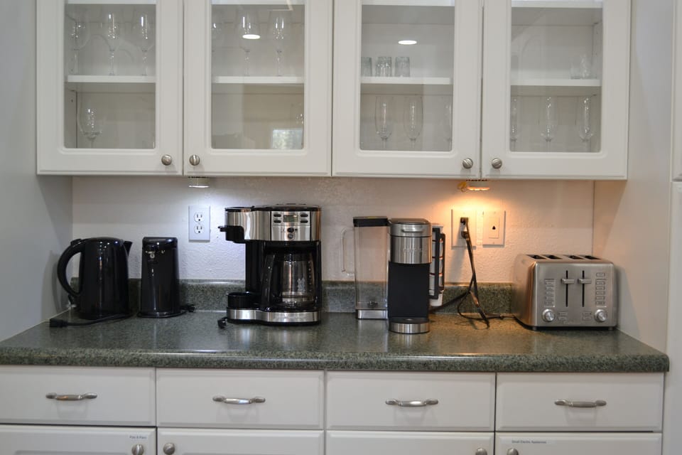 Wine glasses, electric tea pot, can opener, coffee pot, Keurig, and toaster. 
