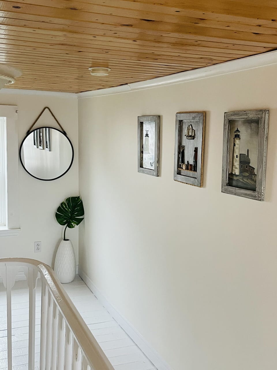 Bright, second floor hallway with nautical themed décor throughout. 