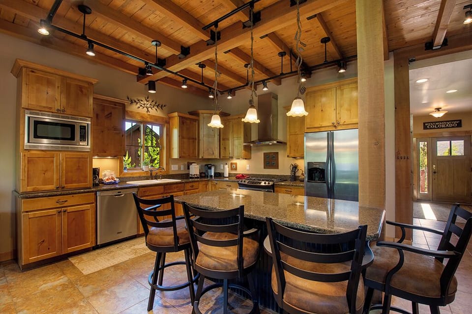 You'll love gathering around this spacious granite island while preparing meals in your fully-equipped mountain kitchen with warm wood beams overhead.