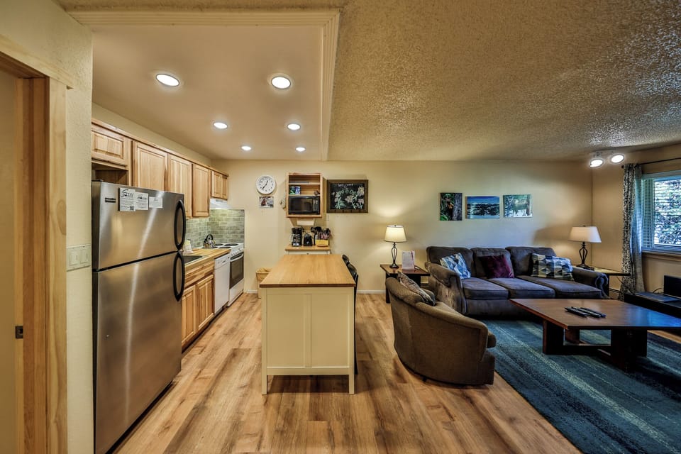 Relax in your spacious open-concept space featuring a fully equipped kitchen and cozy living area with comfortable seating.