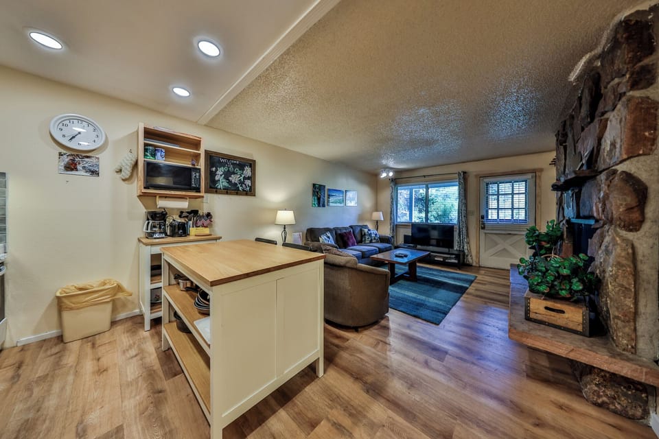 Unwind in your open-concept retreat with a cozy stone fireplace, full kitchen island, and comfortable seating perfect for memorable evenings.