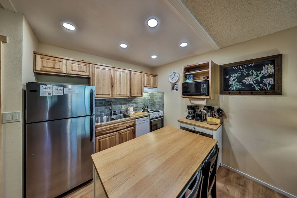 Your fully equipped kitchen welcomes you with warm wood tones, stainless steel appliances, and everything needed to create memorable meals together.