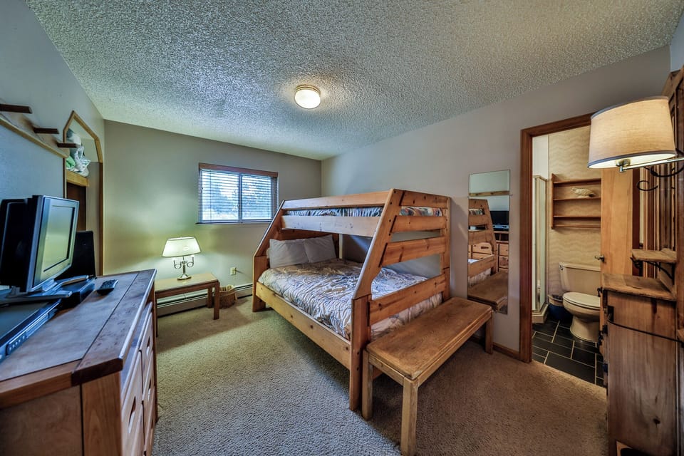 Your cozy bedroom features beautiful wooden bunk beds with comfortable bedding, perfect for families or groups seeking mountain comfort.