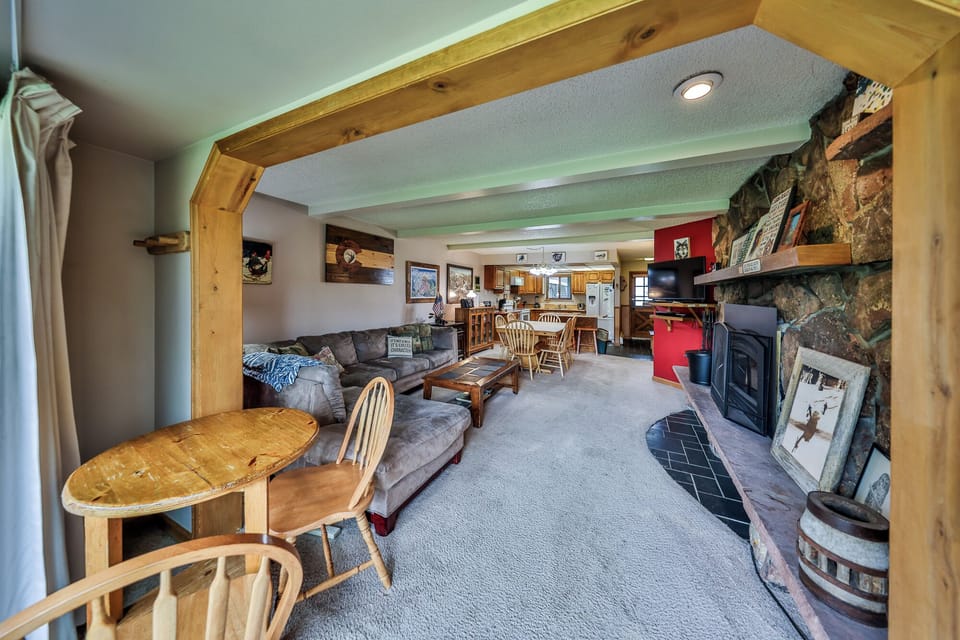 Cozy up in your rustic living space with exposed beams, stone fireplace, and comfortable seating perfect for mountain evenings.