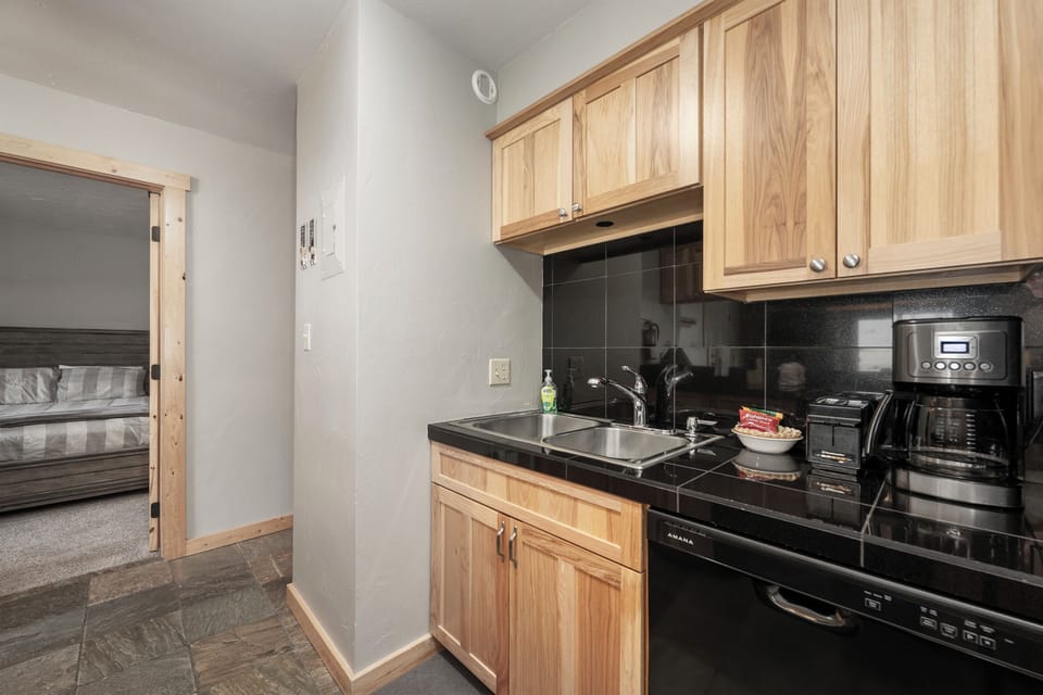 Your fully equipped kitchen features warm wood cabinets, sleek black countertops, and everything you need to prepare meals during your stay.