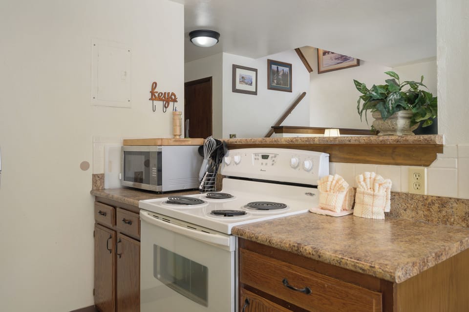 Your fully equipped kitchen awaits with granite counters, stove, microwave, and charming rustic touches for memorable home-cooked meals.