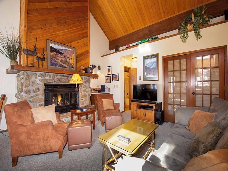 Cozy up by your stone fireplace in this warm living room with vaulted ceilings and rustic charm.