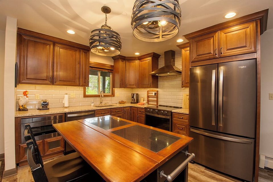 Your fully equipped gourmet kitchen features rich wood cabinetry, granite countertops, and stainless steel appliances for creating memorable meals together.