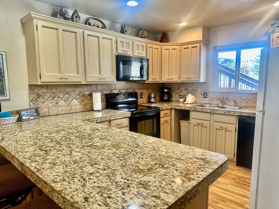 Your fully-equipped kitchen features granite countertops, modern appliances, and warm lighting—perfect for preparing meals during your stay.