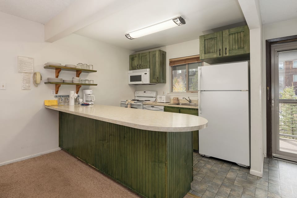 Your fully equipped kitchen features rustic green cabinets, modern appliances, and everything you need to prepare meals during your stay.