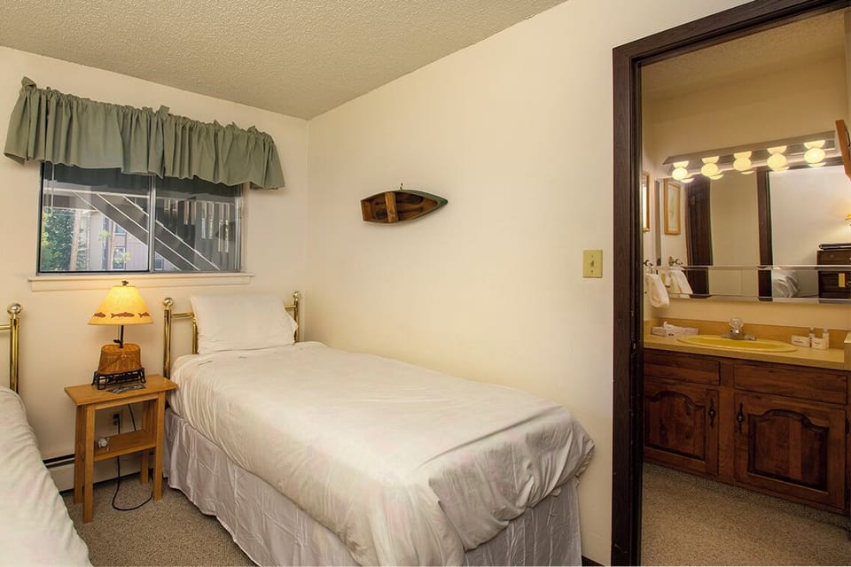 Unwind in your cozy bedroom with comfortable twin beds and convenient ensuite bathroom access for a restful night's sleep.