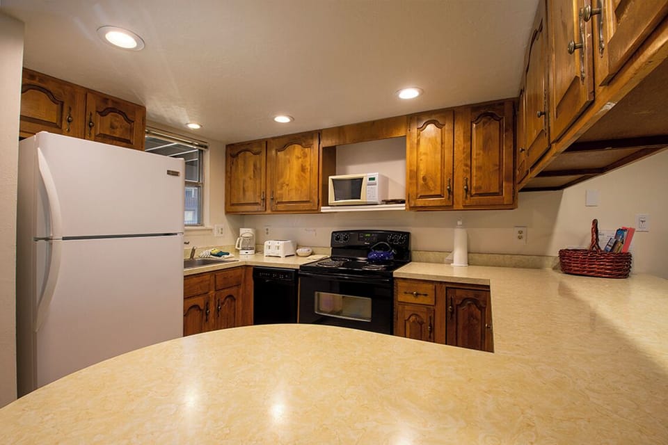 Cook your favorite meals in this fully-equipped kitchen with warm wood cabinets, modern appliances, and spacious countertops for all your culinary adventures.