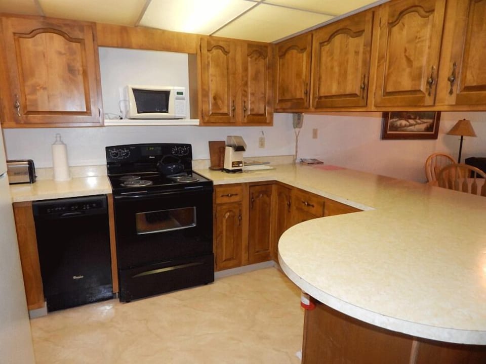 Your fully-equipped kitchen features warm wood cabinets, modern appliances, and a convenient island perfect for preparing meals together.