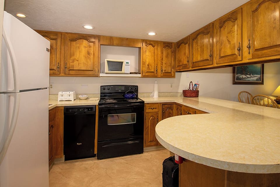 Your fully-equipped kitchen features warm wood cabinets, modern appliances, and spacious countertops perfect for preparing memorable meals during your stay.