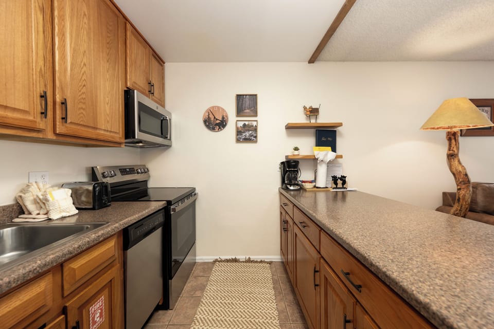 Your fully-equipped kitchen features warm wood cabinetry and granite counters, perfect for preparing homemade meals during your stay.