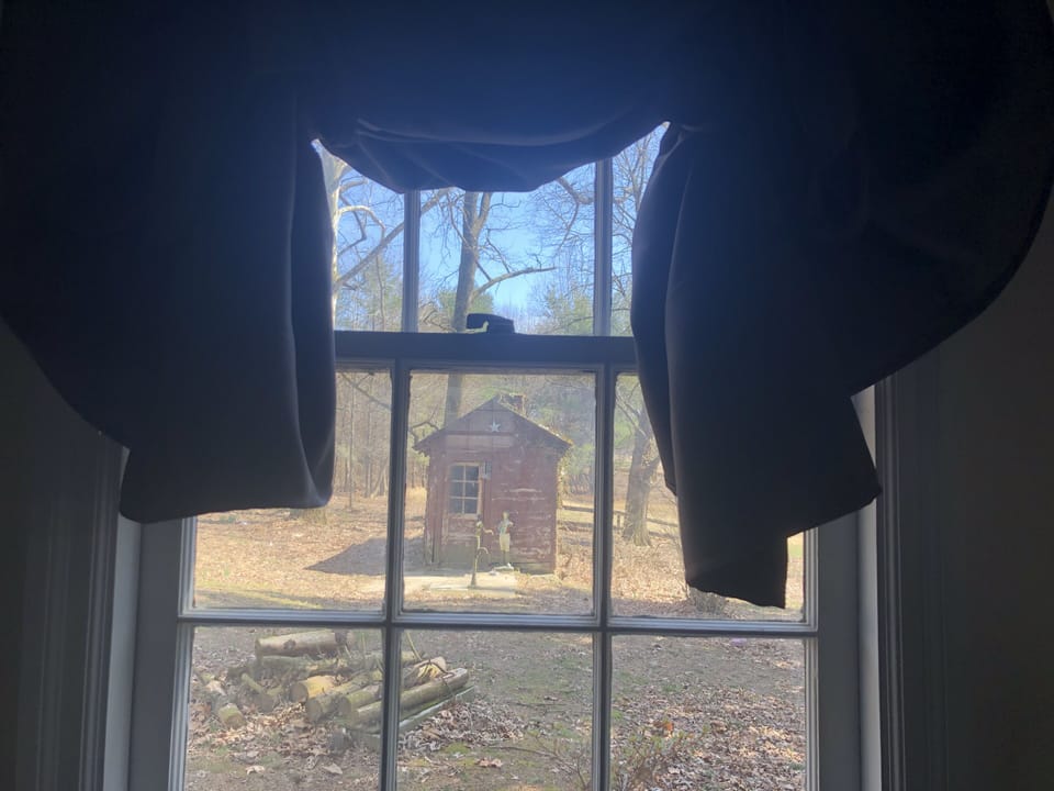 View of the old smokehouse and hand pump
