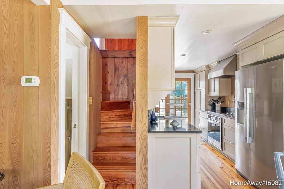 Center stairs up with winders, first-floor full bath left, kitchen right
