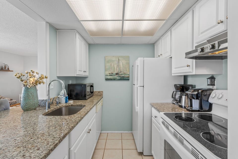 Your fully equipped galley kitchen features granite countertops, crisp white cabinets, and all the appliances you need for home-cooked meals during your stay.