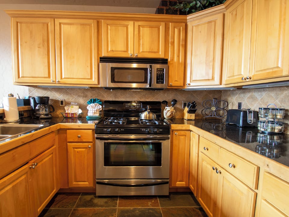 Your fully equipped kitchen awaits with warm wood cabinets, granite counters, and everything needed to create memorable meals.