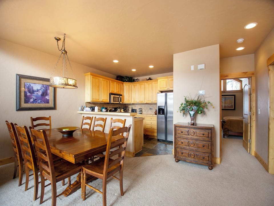 Gather around your spacious dining table in this open-concept space, where warm wood tones and modern amenities create the perfect setting for memorable meals together.