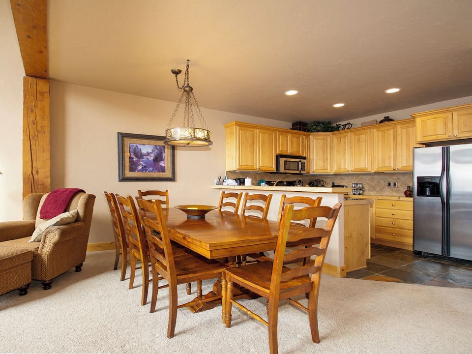 Gather your group around this warm wooden dining table, where rustic charm meets modern comfort in your mountain getaway.