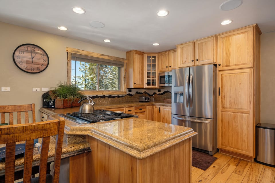 Cook your favorite meals in this fully-equipped kitchen featuring granite counters, stainless appliances, and warm wood cabinetry.