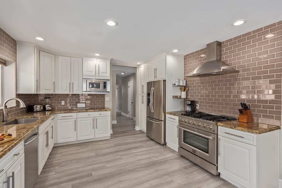 Large and open kitchen fully equipped with high-end stainless steel appliances and stocked with all culinary essentials for convenience.