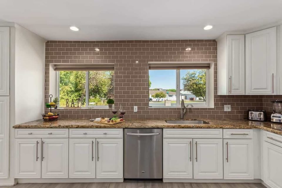 Large and open kitchen fully equipped with high-end stainless steel appliances and stocked with all culinary essentials for convenience.