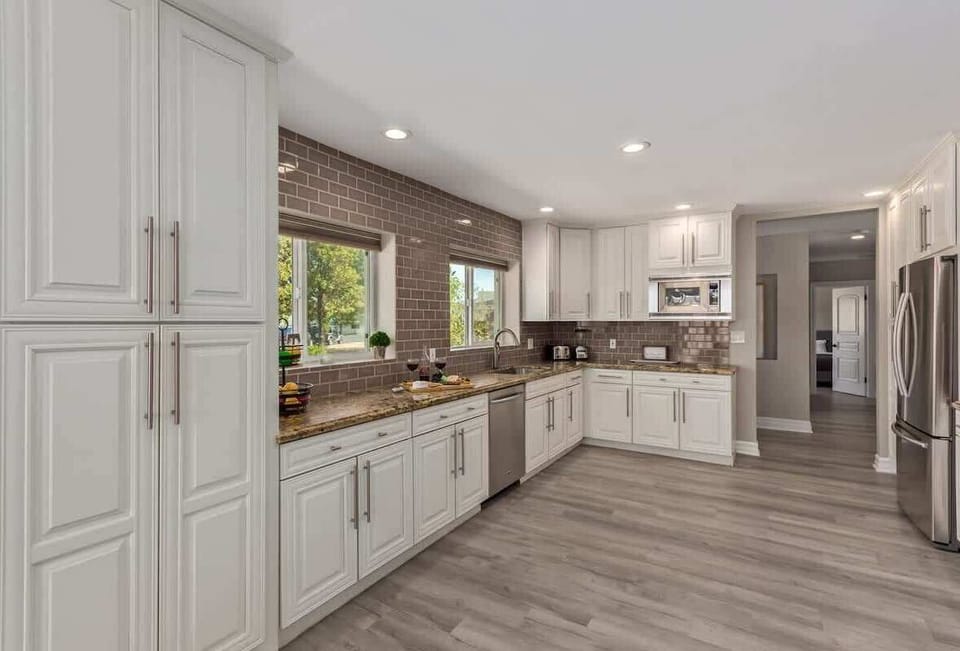 Large and open kitchen fully equipped with high-end stainless steel appliances and stocked with all culinary essentials for convenience.