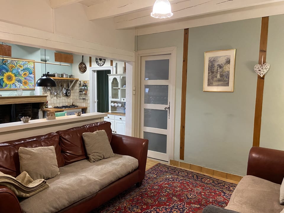 Comfy living room with downstairs bedroom entrance door.