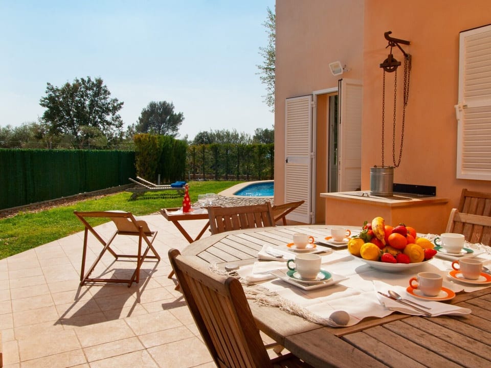 Outside dining table in the courtyard of the house with a waterwell.