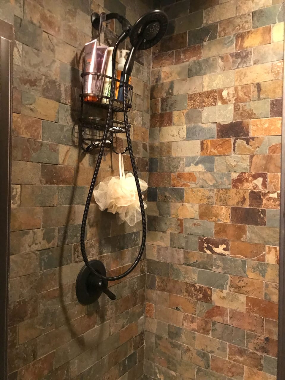 Main floor bathroom walk in shower with slate tile, also has a bench