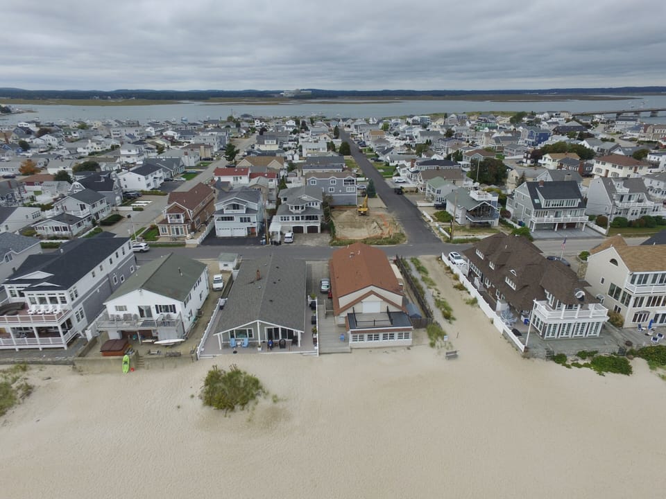 The condo is on the left-hand side of the green house in front of the dune.