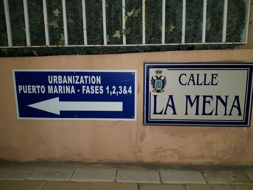 This sign can be seen to the lefthand side of the Puerto Marina Suites