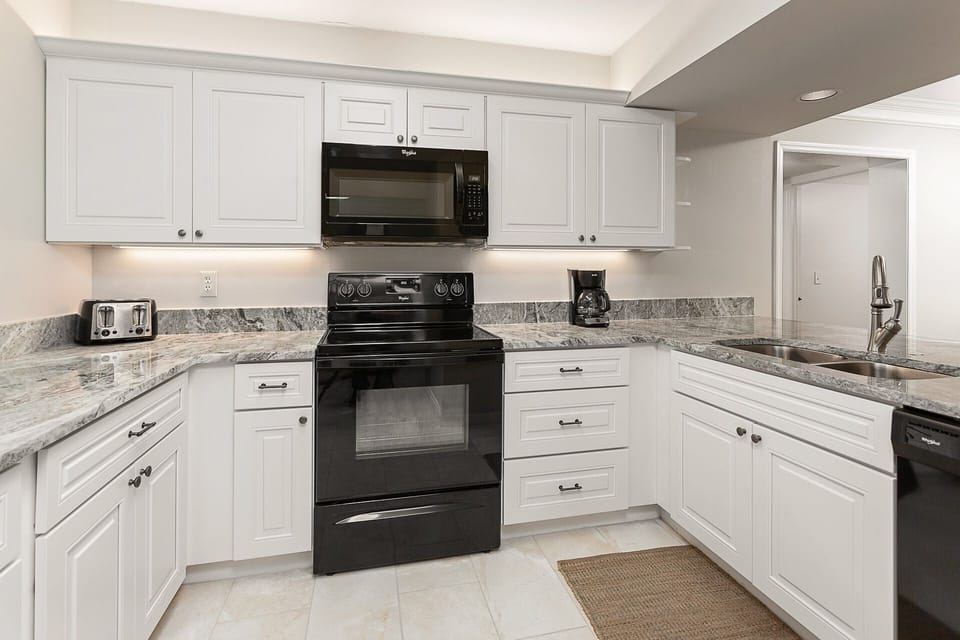 Kitchen with new appliances , cabinets, granite surfaces, & marble floors