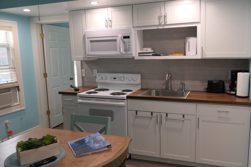 kitchen counter with sove/oven, microwave, kettle, coffee machine, toaster