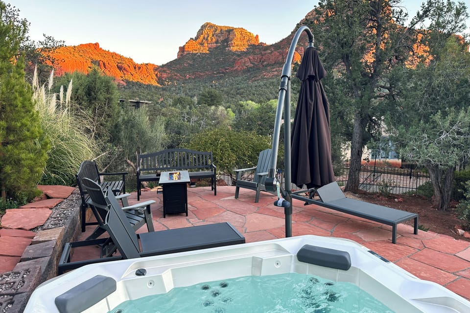 Private hot tub open, fire pit lit, red rock canyon glowing at sunset