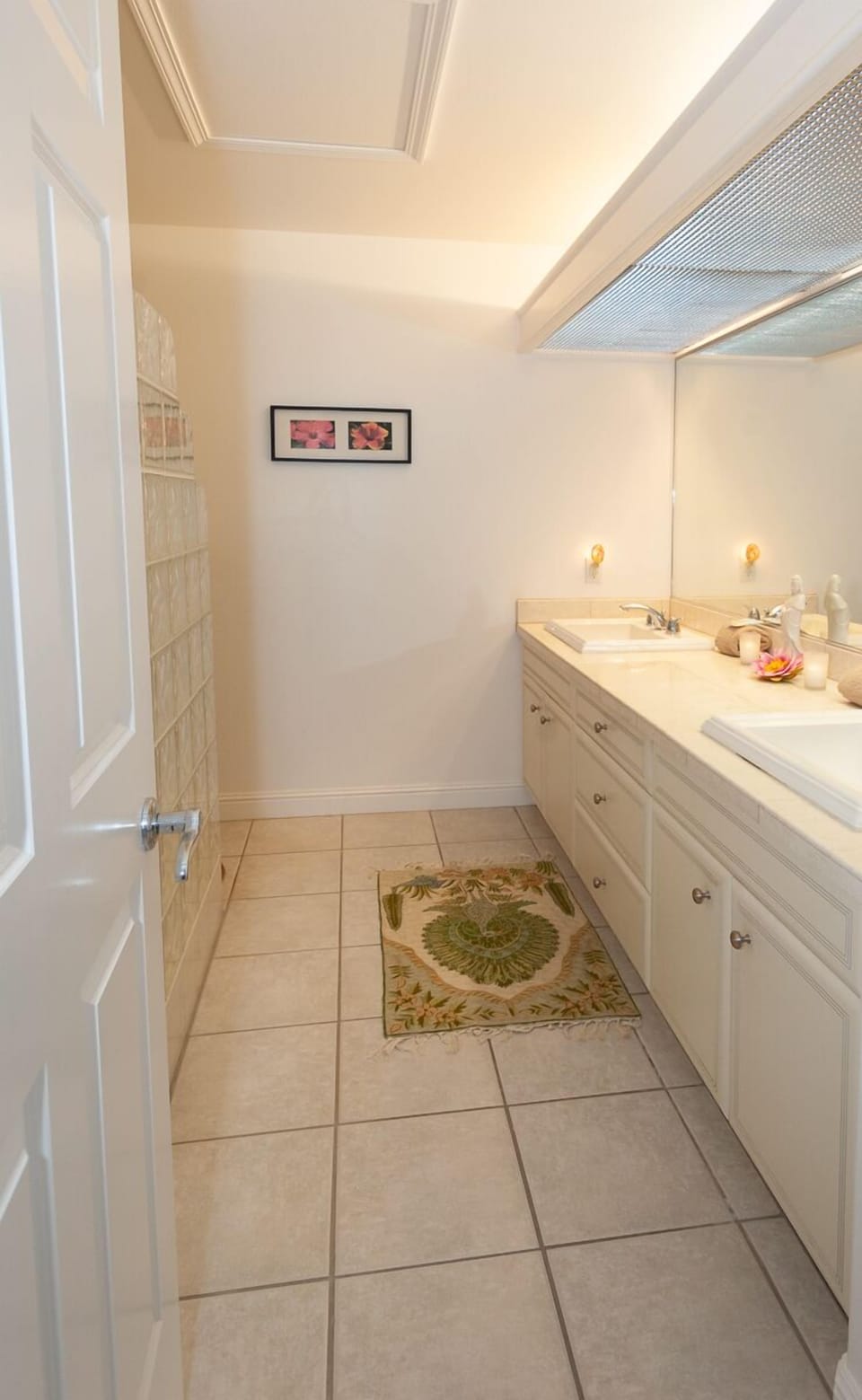 The ensuite bathroom has a large double vanity, and a glass-tiled walk-in shower