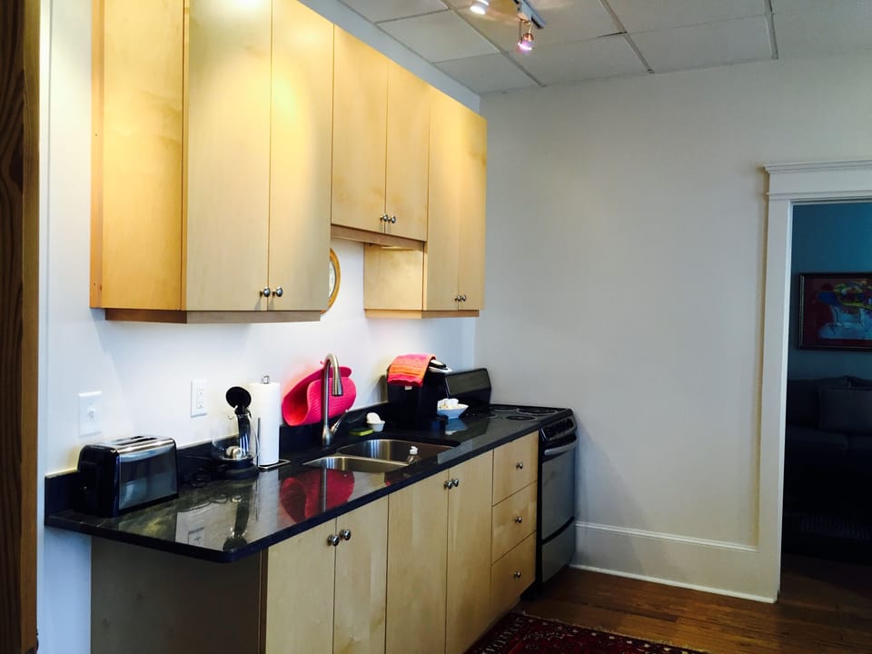 Kitchen area with stove, small appliances. Granite countertop. Keurig coffee.