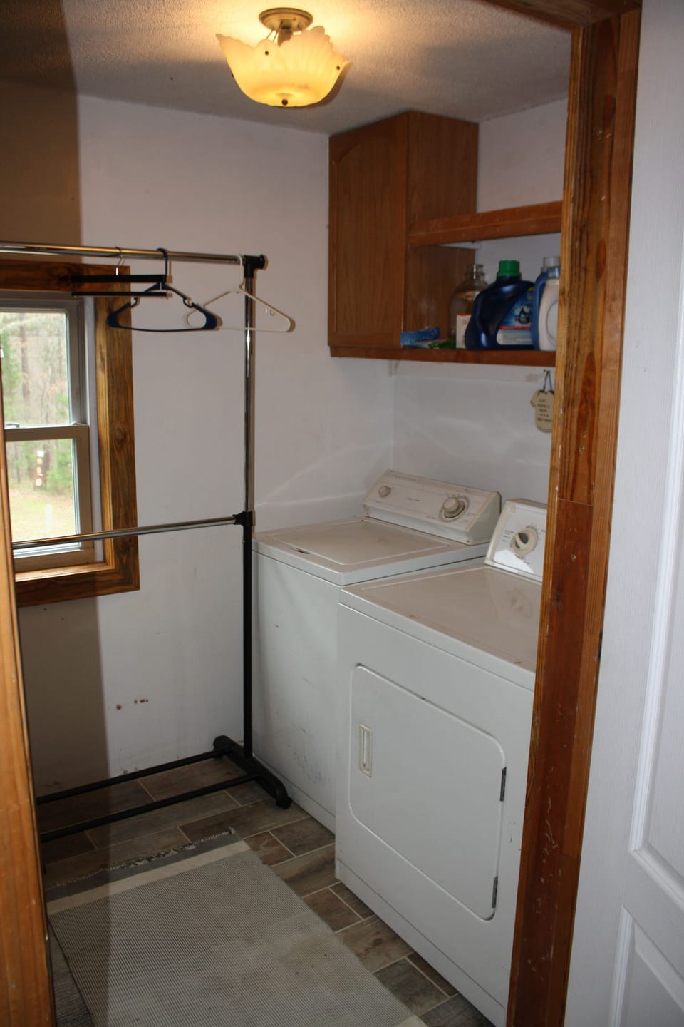 Full laundry room with washer, dryer, and hanging rack