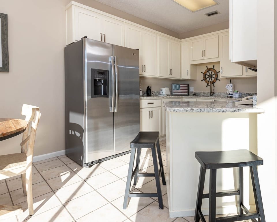 Gather around the cozy dining table in the kitchen, featuring sleek appliances and charming nautical decor