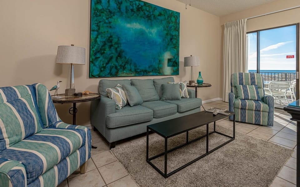 Relax in the inviting living area, featuring comfortable seating, queen sofa sleeper, and a vibrant artwork