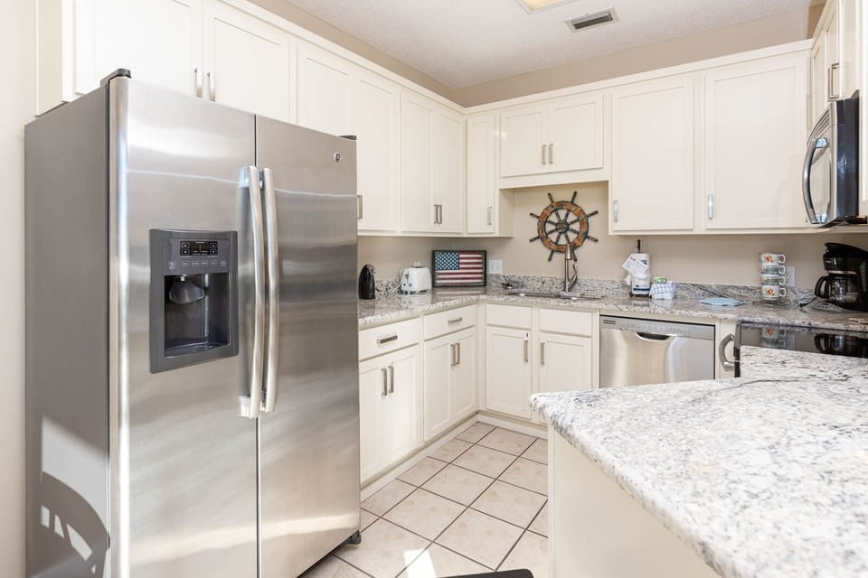 Prepare meals in this bright kitchen featuring stainless appliances and charming nautical accents