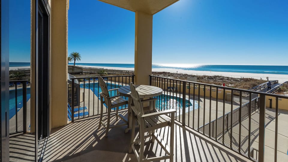 Sunlight glinting on the pool as your family chats on your balcony with the shore in view