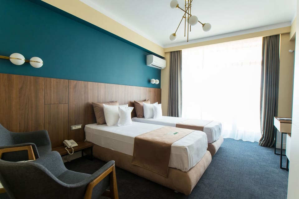 Twin Room | Minibar, in-room safe, individually decorated, desk