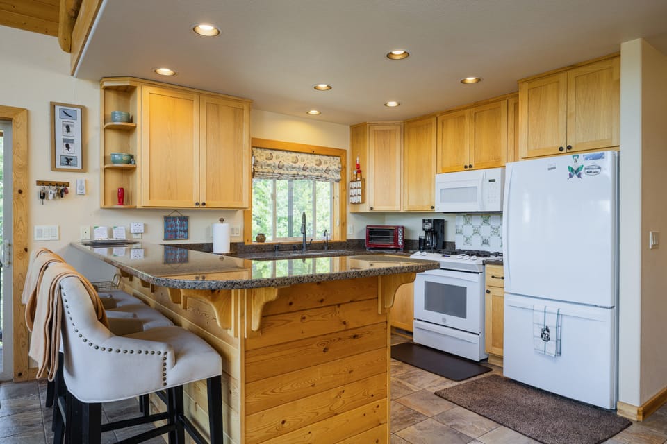 Fully stocked kitchen with bar and bar stools 