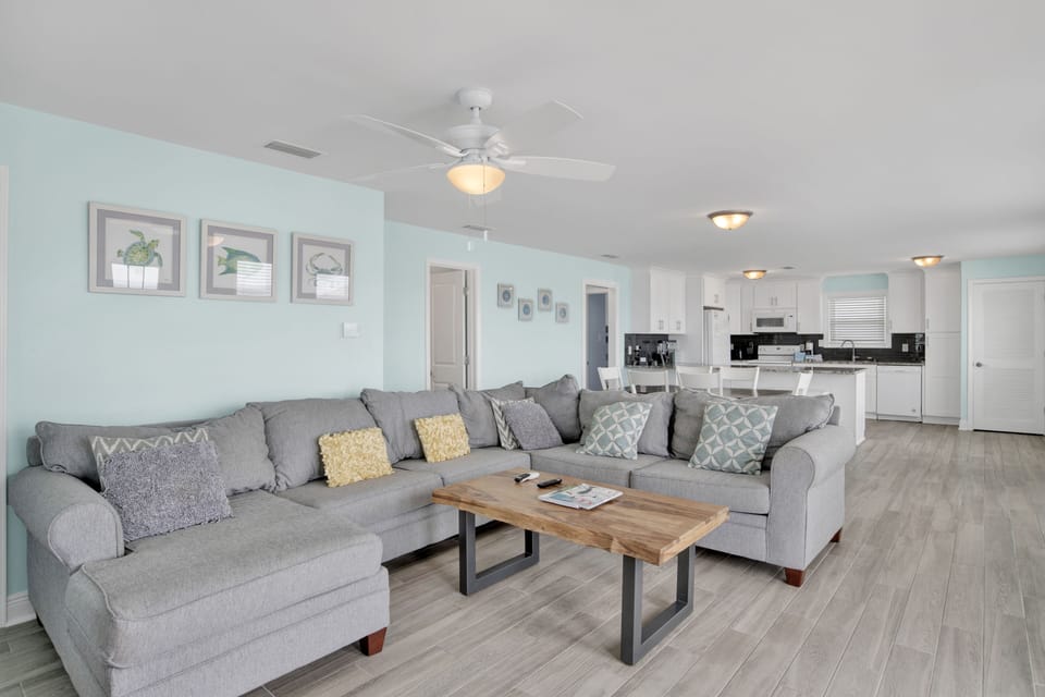 Living area features a large sectional that also doubles as a sofa sleeper for 2, TV, and access to the beach front deck