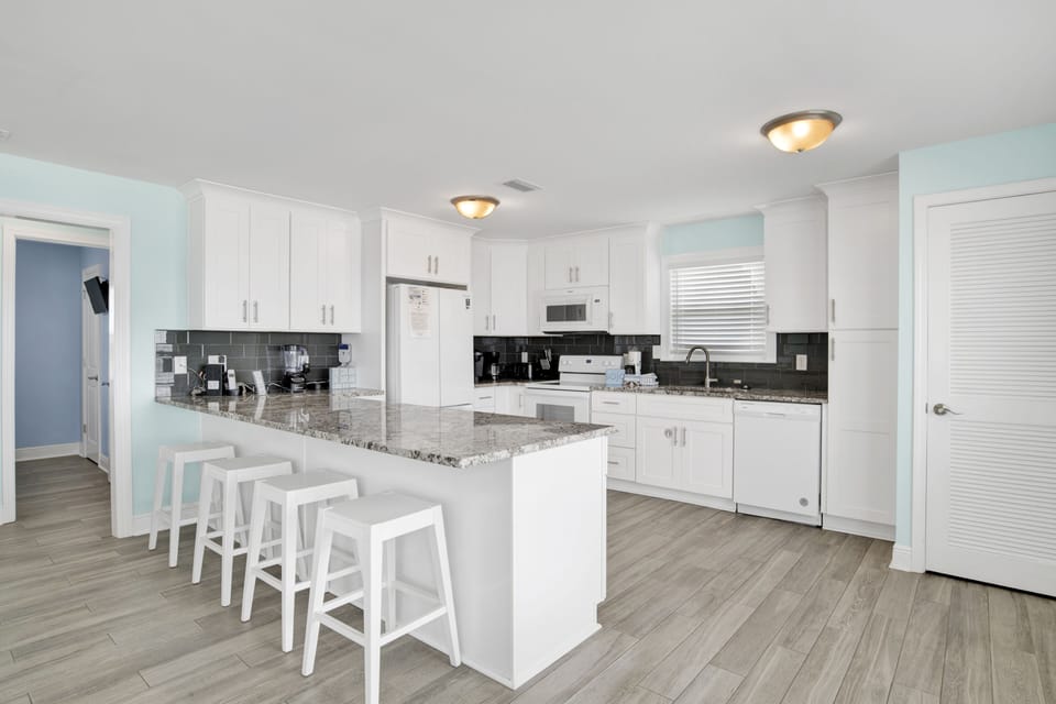 Spacious kitchen with granite countertops, significant counter space, and bar seating for 4