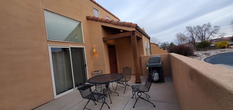 Private patio with extra seating, gas grill, and sliding door access.