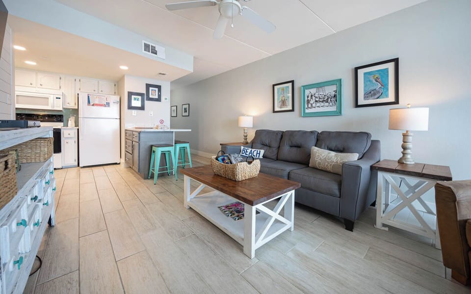 This condo features a cozy seating area with a stylish coffee table, leading to a well-equipped kitchen